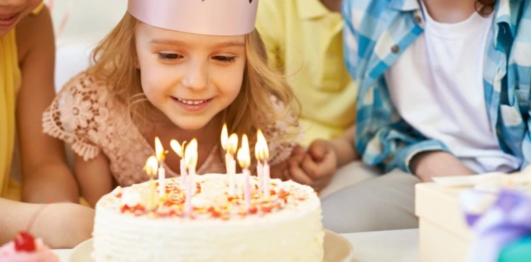 urodziny dmuchanie świeczek przez dziewczynkę